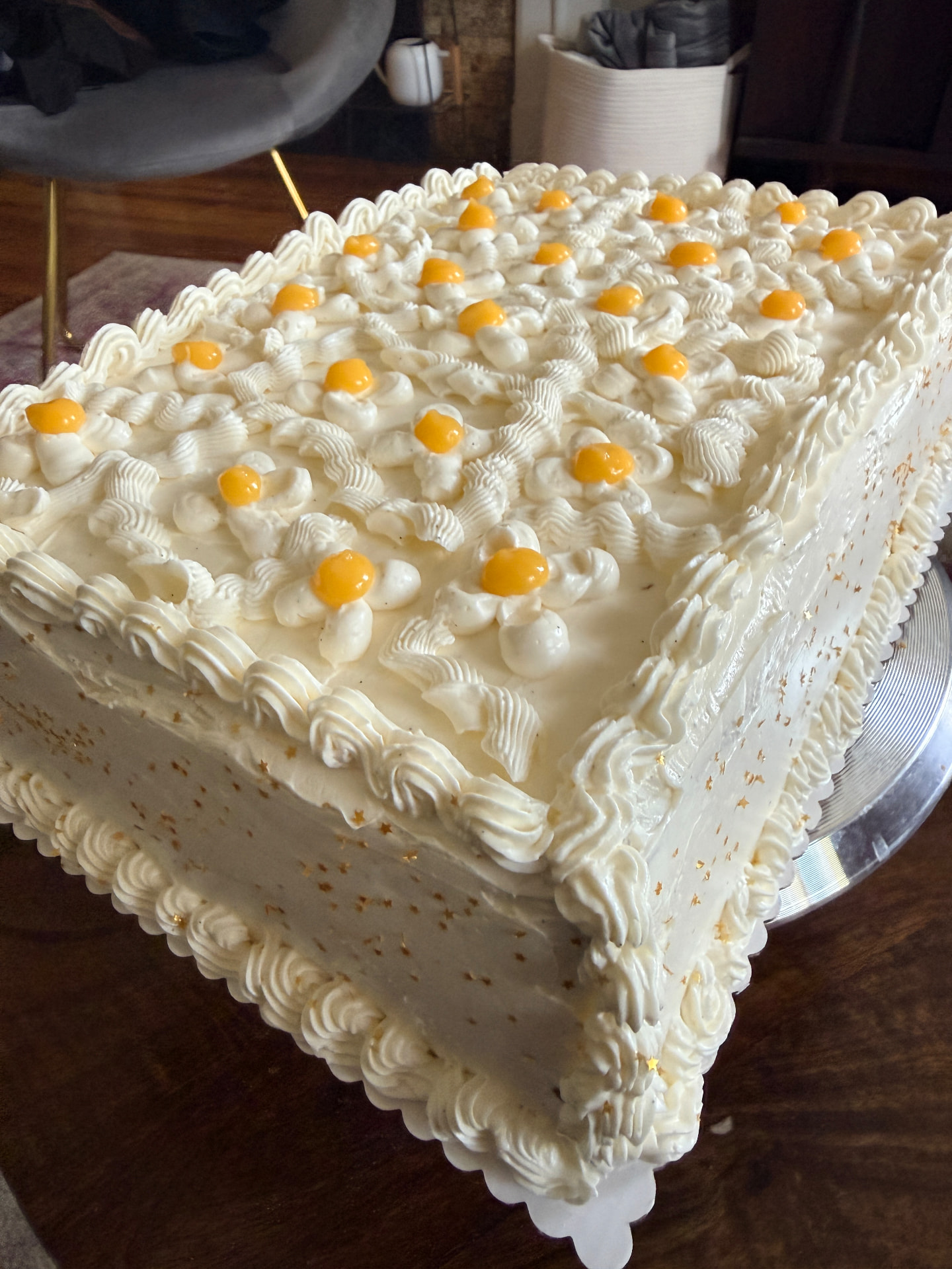 A large vanilla sheet cake piped with cream rosettes and lemon curd centers